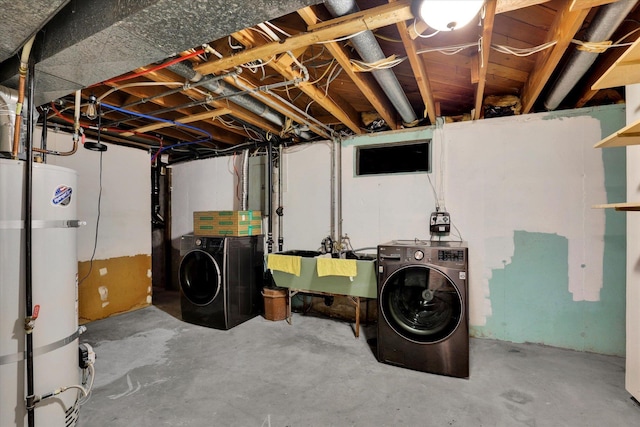 basement with washing machine and clothes dryer, sink, and water heater