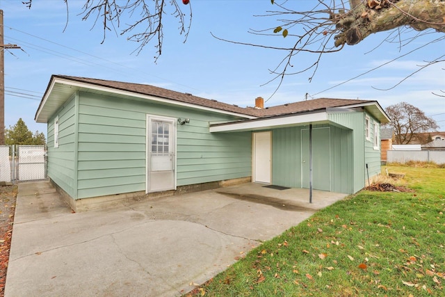 back of house featuring a lawn and a patio