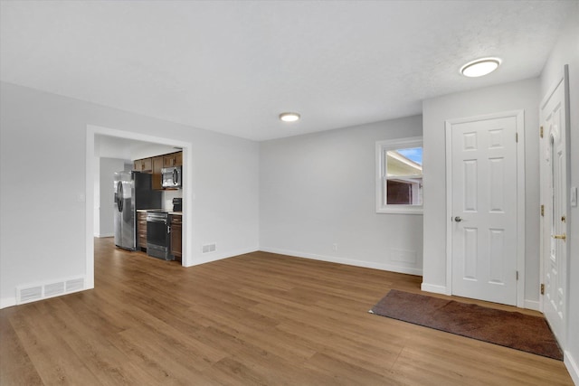 empty room with light hardwood / wood-style flooring