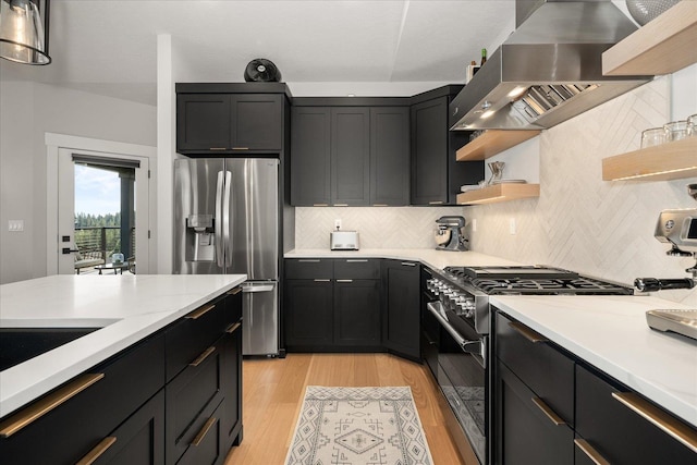 kitchen featuring wall chimney exhaust hood, stainless steel appliances, light stone counters, light hardwood / wood-style flooring, and backsplash