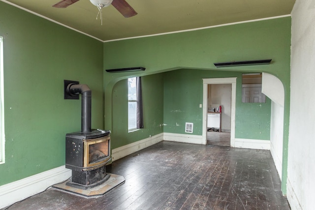 unfurnished living room with hardwood / wood-style floors, ceiling fan, and a wood stove