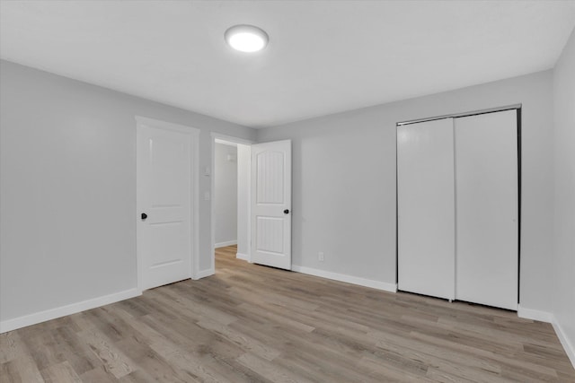 unfurnished bedroom with a closet and light hardwood / wood-style floors