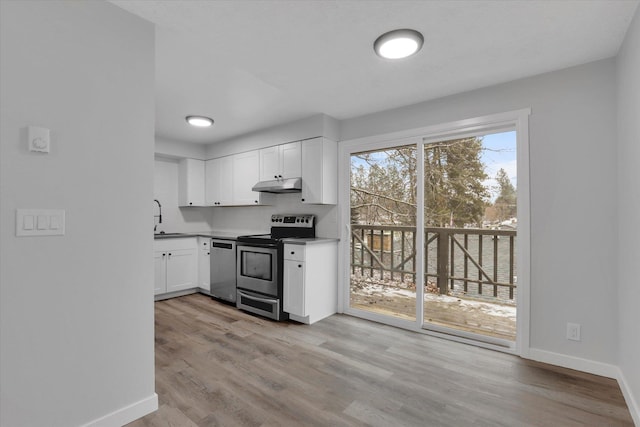 kitchen featuring sink, high quality fridge, decorative backsplash, white cabinets, and light wood-type flooring