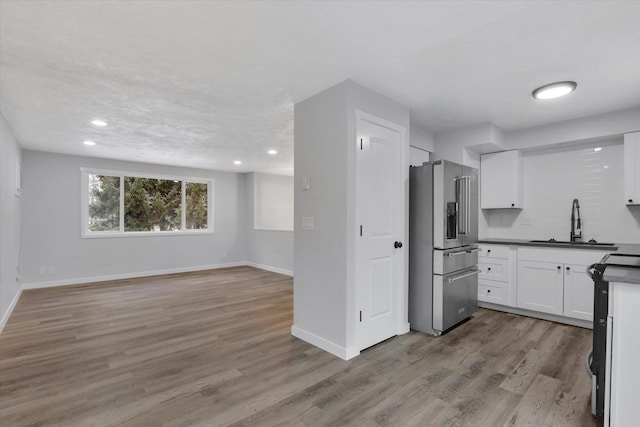 kitchen featuring light hardwood / wood-style flooring, stainless steel appliances, white cabinetry, and sink