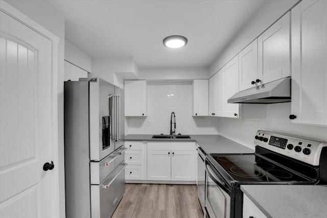 kitchen featuring appliances with stainless steel finishes, light hardwood / wood-style floors, white cabinetry, and sink