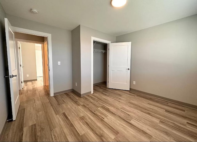 unfurnished bedroom featuring a closet and light wood-type flooring