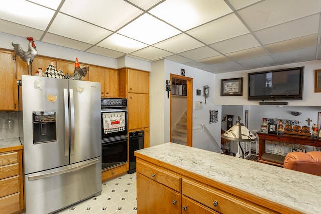 kitchen with stainless steel fridge, a paneled ceiling, and double oven