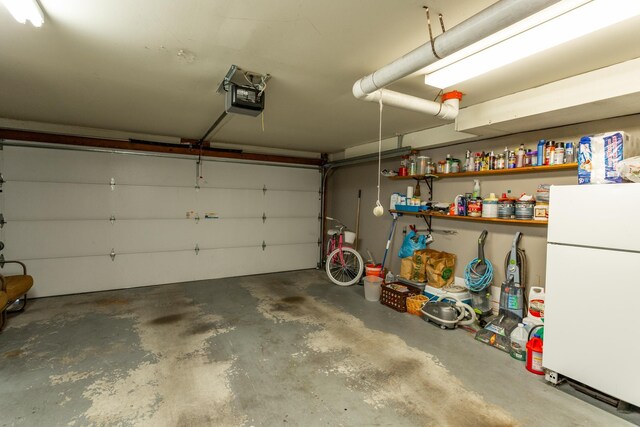 garage with white refrigerator and a garage door opener