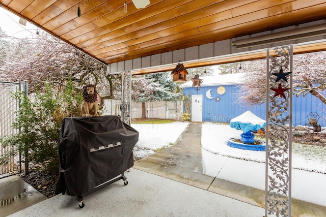 snow covered patio with a grill