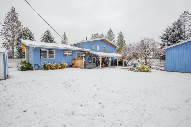 rear view of property with a hot tub