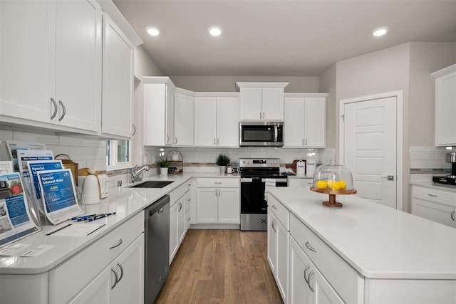 kitchen featuring white cabinets, wood-type flooring, and stainless steel appliances