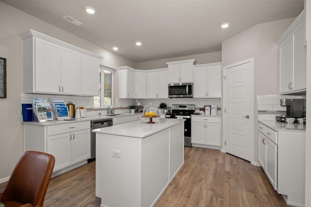 kitchen with white cabinetry, a center island, and appliances with stainless steel finishes