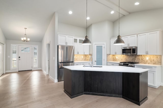 kitchen featuring stainless steel appliances, a center island with sink, light hardwood / wood-style floors, and sink