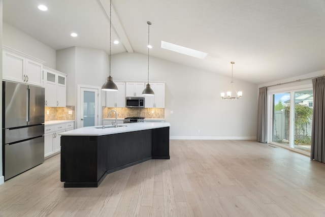 kitchen featuring white cabinetry, sink, appliances with stainless steel finishes, and a skylight