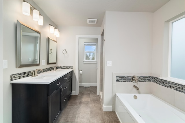 bathroom featuring a bathing tub, tile patterned flooring, and vanity