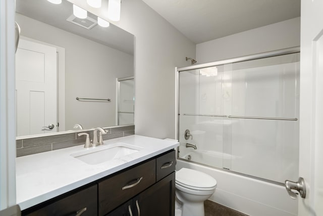 full bathroom with vanity, toilet, and bath / shower combo with glass door