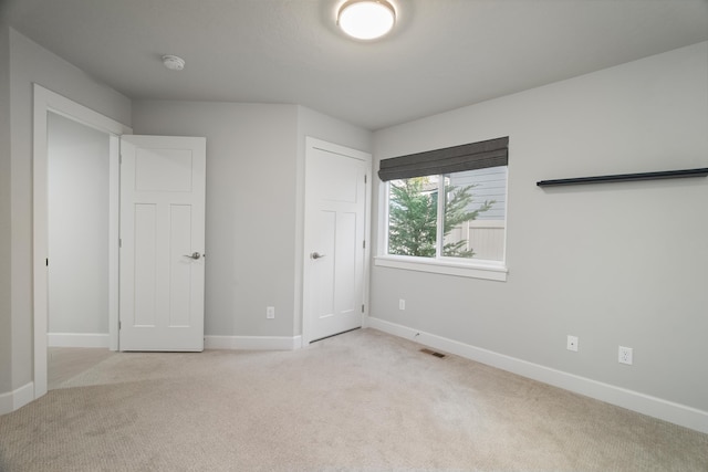 unfurnished bedroom featuring light carpet