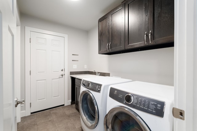 laundry area with washing machine and clothes dryer, sink, light tile patterned floors, and cabinets