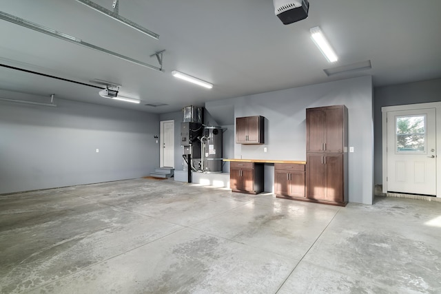 garage featuring secured water heater, a workshop area, and a garage door opener