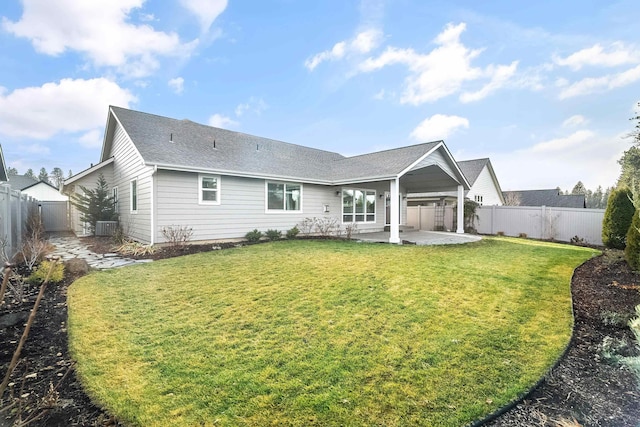 rear view of property with a lawn, cooling unit, and a patio