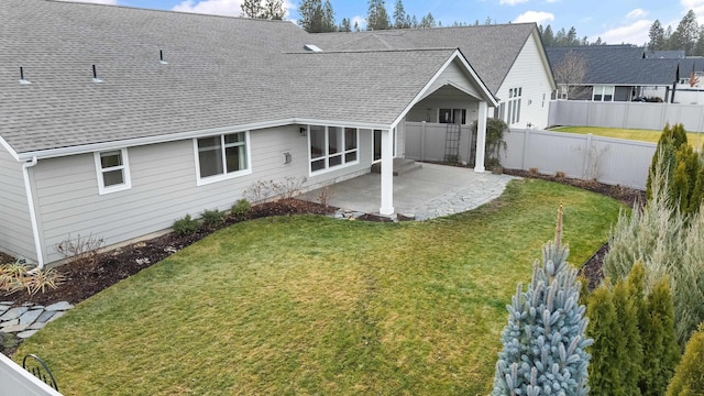 back of house with a yard and a patio