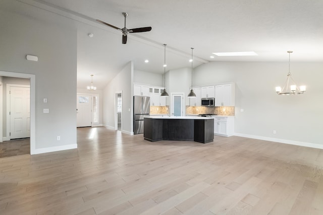 kitchen with appliances with stainless steel finishes, a center island, white cabinetry, and hanging light fixtures