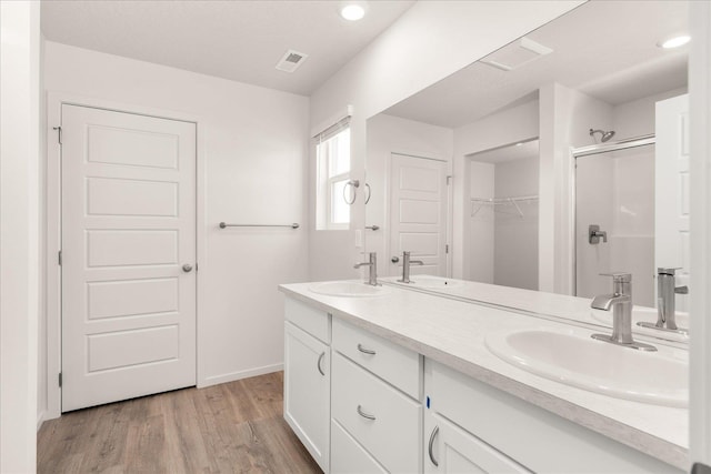 bathroom featuring vanity, wood-type flooring, and walk in shower