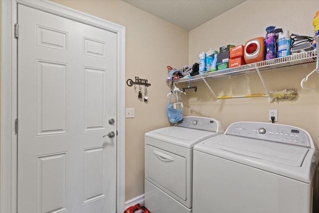 clothes washing area with independent washer and dryer and a textured ceiling