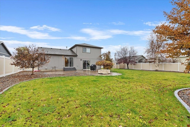 back of house featuring a lawn and a patio area