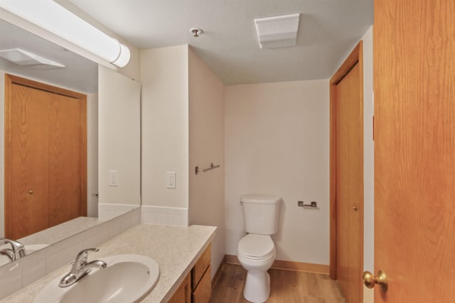 bathroom with vanity, wood-type flooring, and toilet