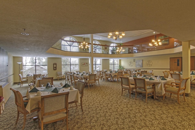 dining room with plenty of natural light, carpet floors, a textured ceiling, and a chandelier