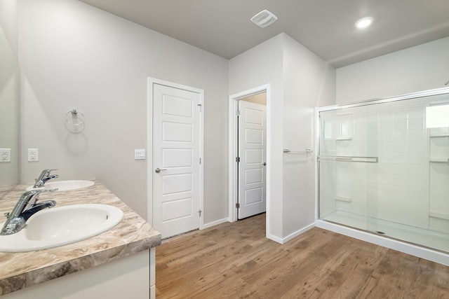 bathroom featuring hardwood / wood-style floors, vanity, and a shower with door