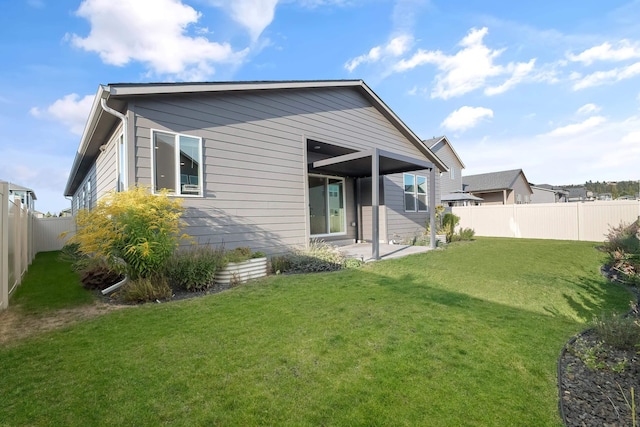 back of property featuring a patio area and a yard