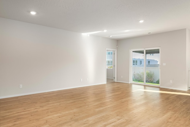 spare room featuring a textured ceiling and light wood-type flooring