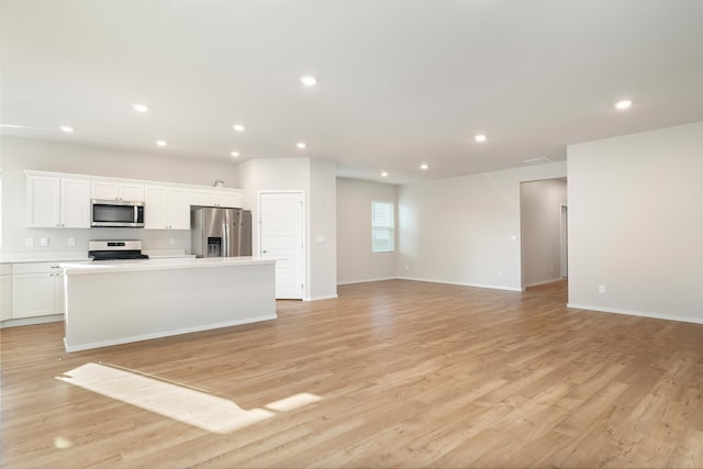 kitchen with a center island, white cabinets, light hardwood / wood-style flooring, and appliances with stainless steel finishes