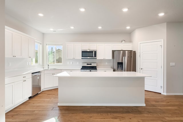 kitchen with a kitchen island, sink, white cabinetry, and stainless steel appliances