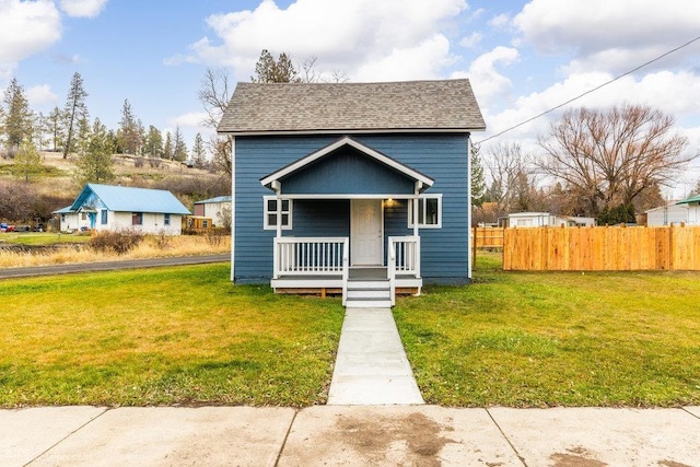 bungalow with covered porch and a front yard