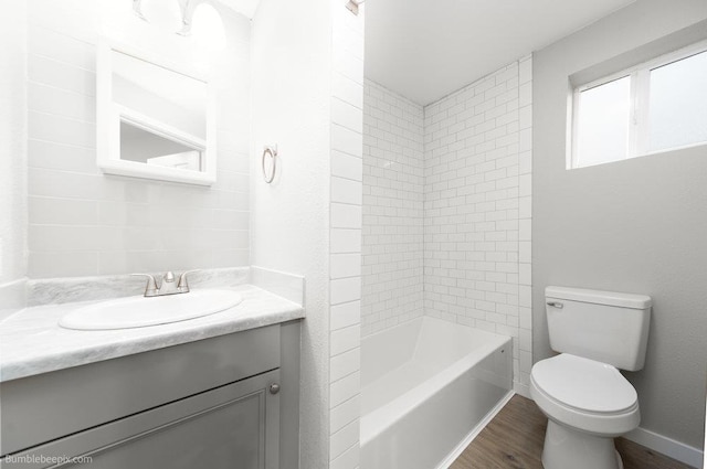 full bathroom featuring wood-type flooring, vanity, toilet, and tiled shower / bath