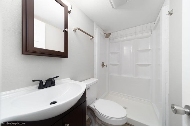 bathroom with vanity, toilet, and a shower