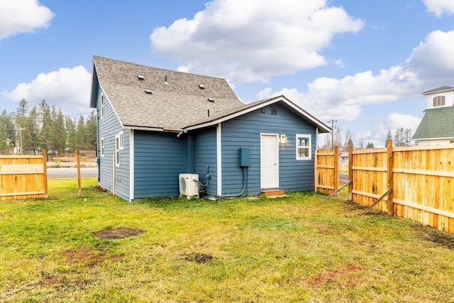 back of property with ac unit and a lawn