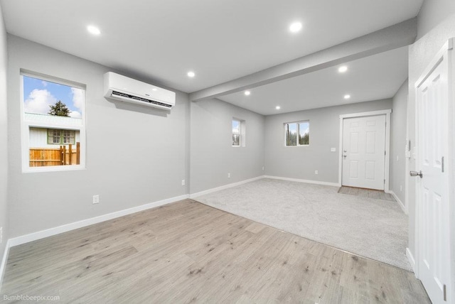 basement with a wall mounted AC and light colored carpet