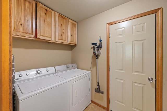 clothes washing area with cabinets and washer and clothes dryer