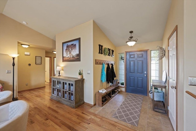 entrance foyer with lofted ceiling and light hardwood / wood-style flooring