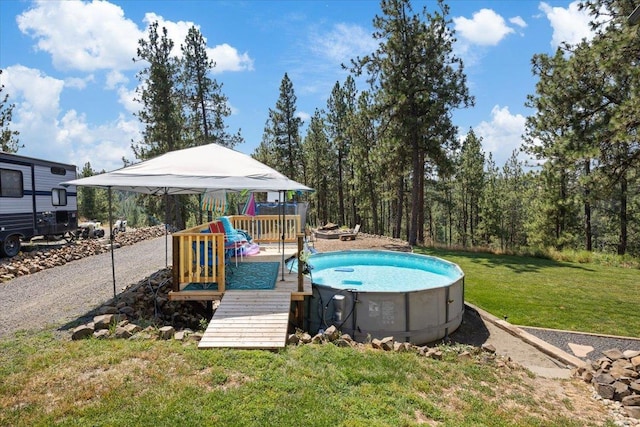 view of swimming pool featuring a deck and a yard