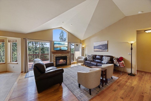 living room featuring a fireplace, light hardwood / wood-style floors, and lofted ceiling