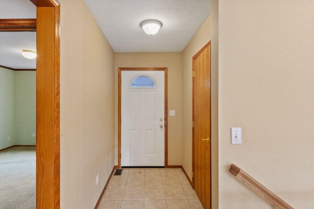 doorway with light tile patterned flooring and a textured ceiling