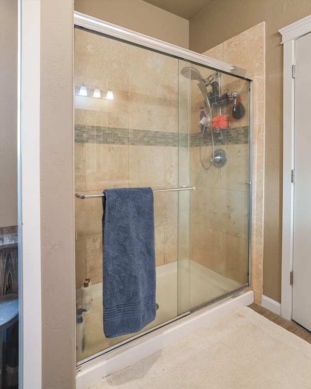 bathroom with hardwood / wood-style floors and a shower with door