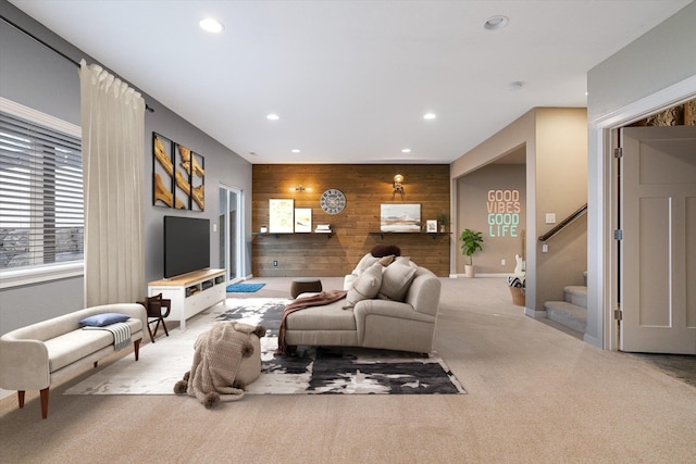 living room with light carpet and wooden walls