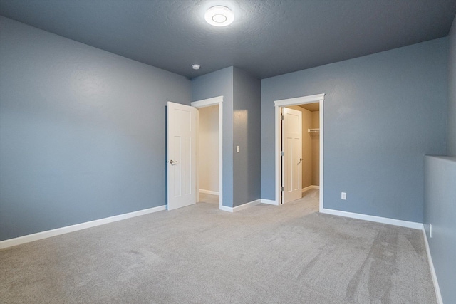 unfurnished bedroom with light colored carpet and a textured ceiling