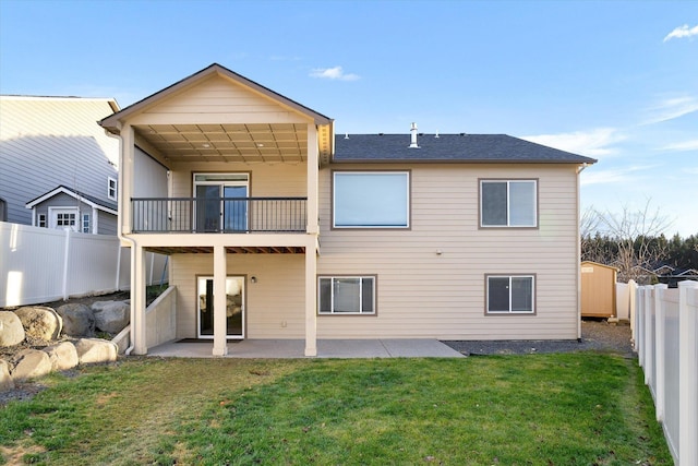 rear view of property with a lawn, a balcony, and a patio